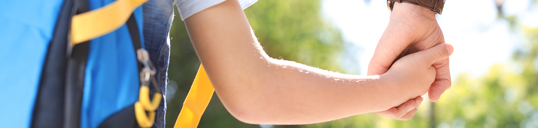 student holding adults hand